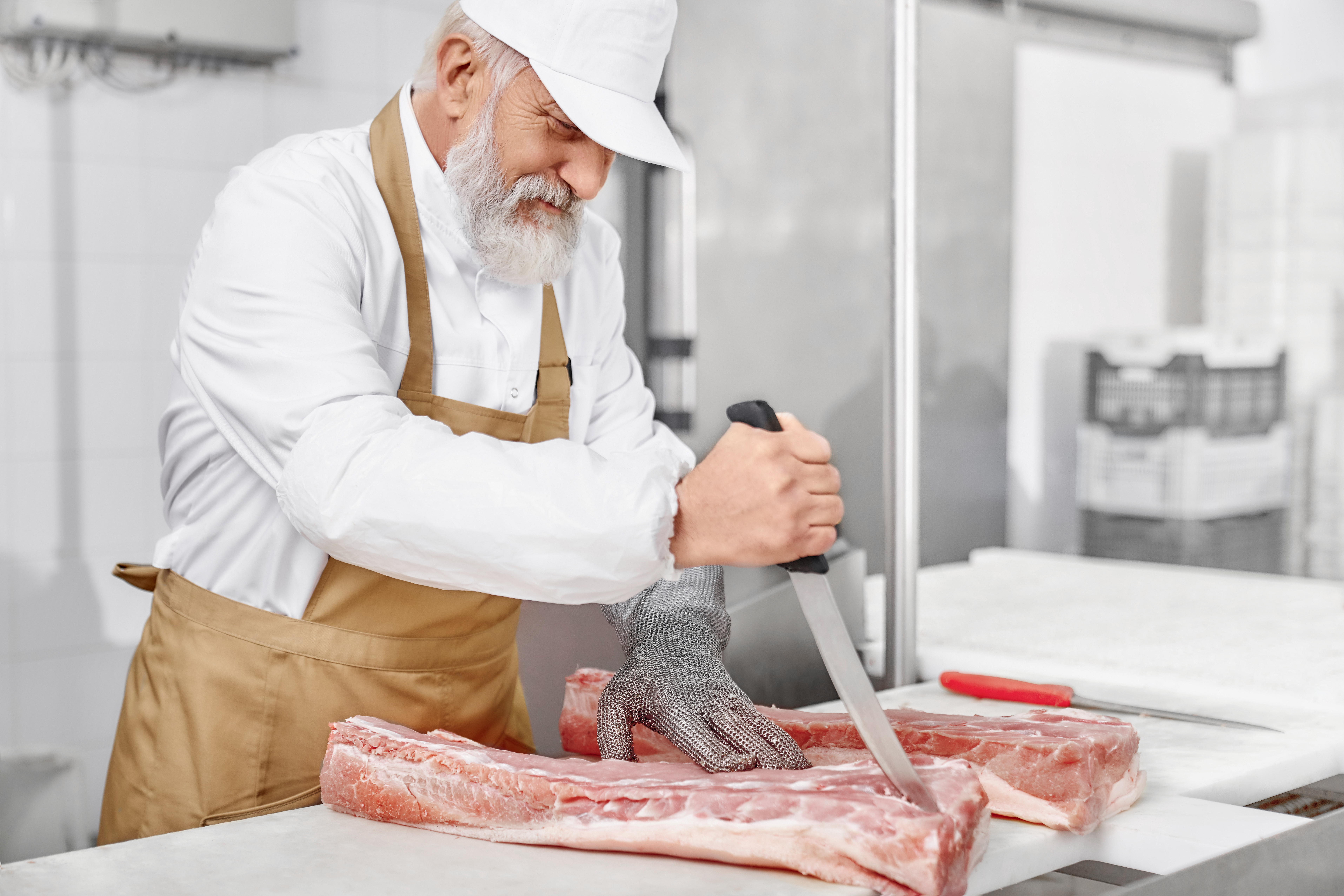 Boucher découpant de la viande dans un atelier